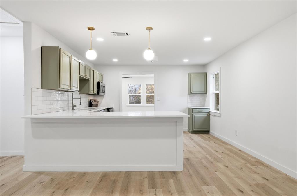 1221 Chestnut Street Waco, TX 76704 - Photo 8 of 32 a large kitchen with kitchen island a sink stainless steel appliances and a counter space