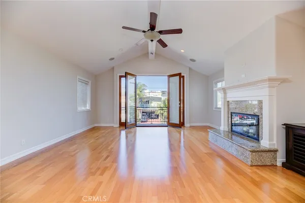 a view of an empty room with window and wooden floor