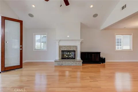 an empty room with windows and fireplace