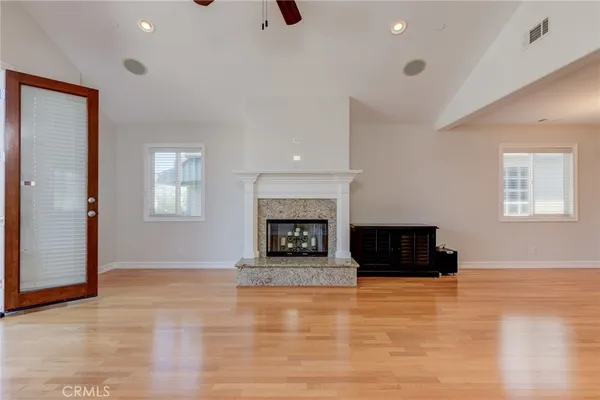 an empty room with windows and fireplace