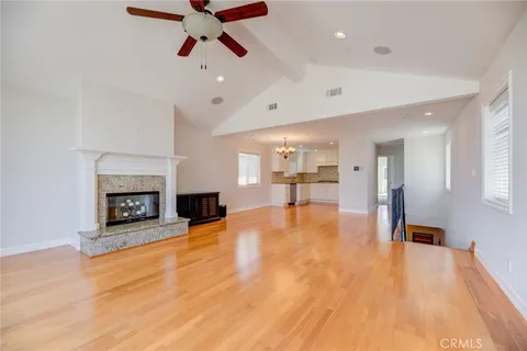 a view of an empty room with a fireplace and window