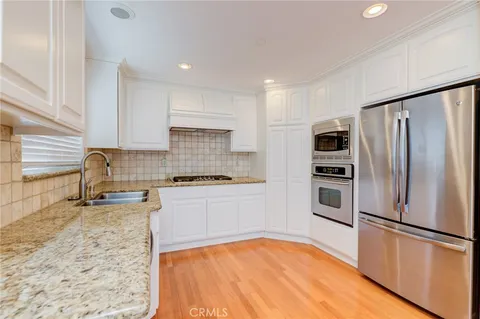 a kitchen with granite countertop a refrigerator and a sink