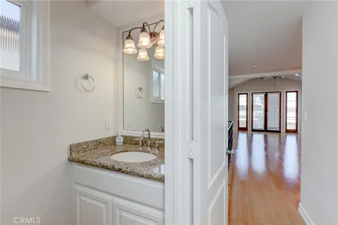 a bathroom with granite countertop a sink and a mirror
