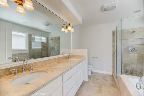 a bathroom with a granite countertop sink a mirror and a shower