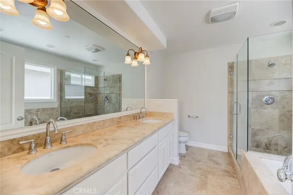 a bathroom with a granite countertop sink a mirror and a shower