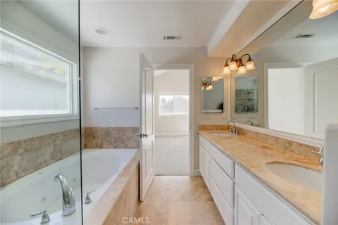 a spacious bathroom with a granite countertop tub sink and mirror