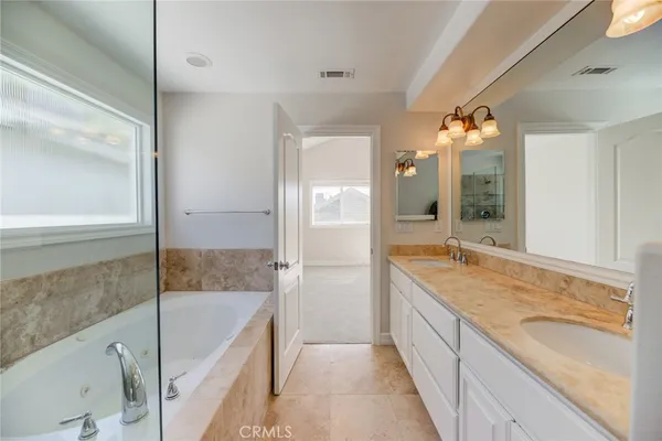 a spacious bathroom with a granite countertop tub sink and mirror