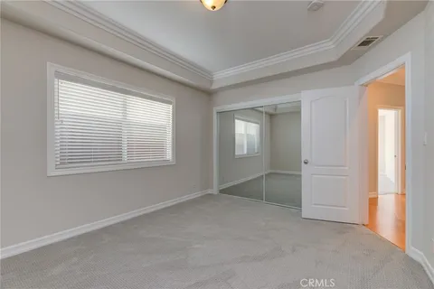a view of an empty room with closet and a window