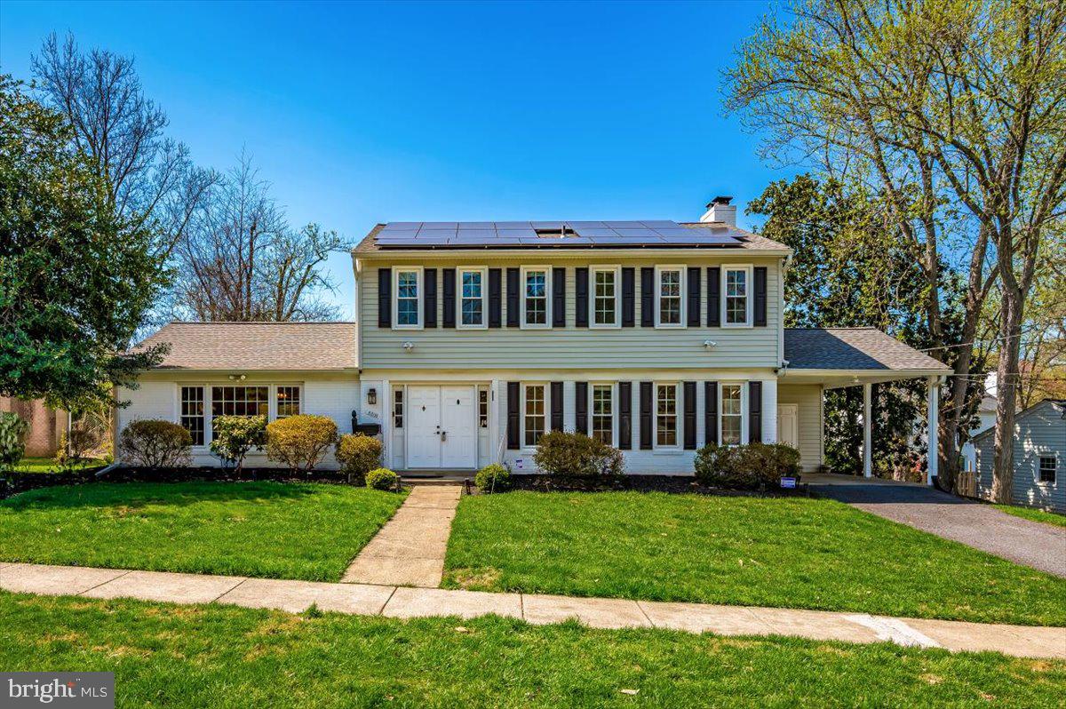 a front view of a house with a yard table and trees