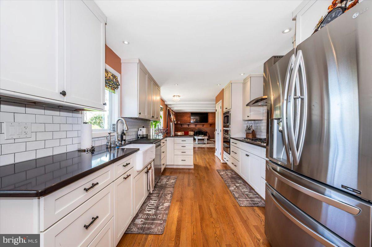 8803 Postoak Road Potomac, MD 20854 - Photo 21 of 66 a large kitchen with stainless steel appliances sink a microwave and cabinets