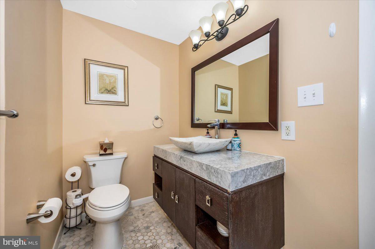 8803 Postoak Road Potomac, MD 20854 - Photo 32 of 66 a bathroom with a granite countertop toilet sink and mirror