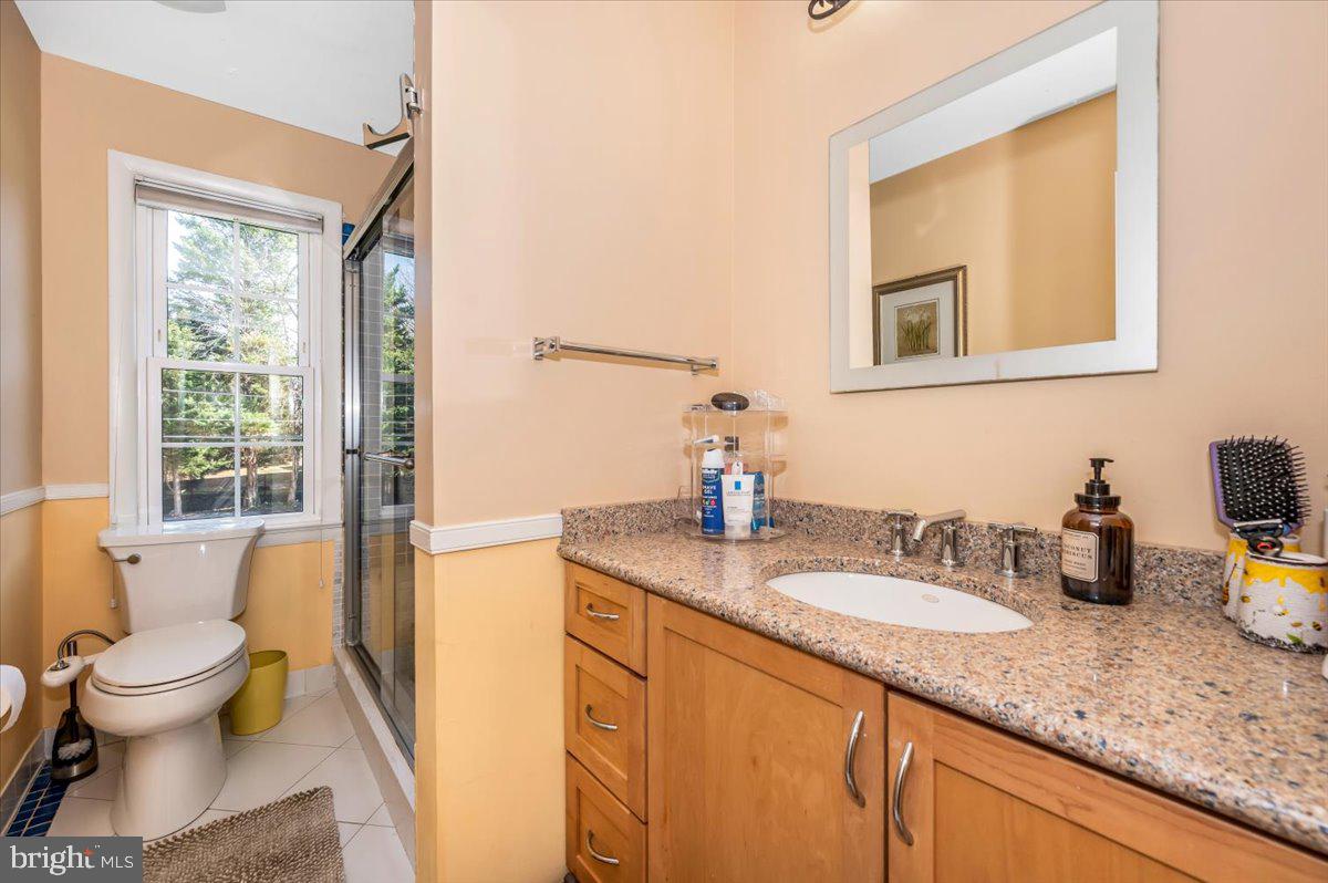 8803 Postoak Road Potomac, MD 20854 - Photo 38 of 66 a bathroom with a granite countertop sink mirror and toilet