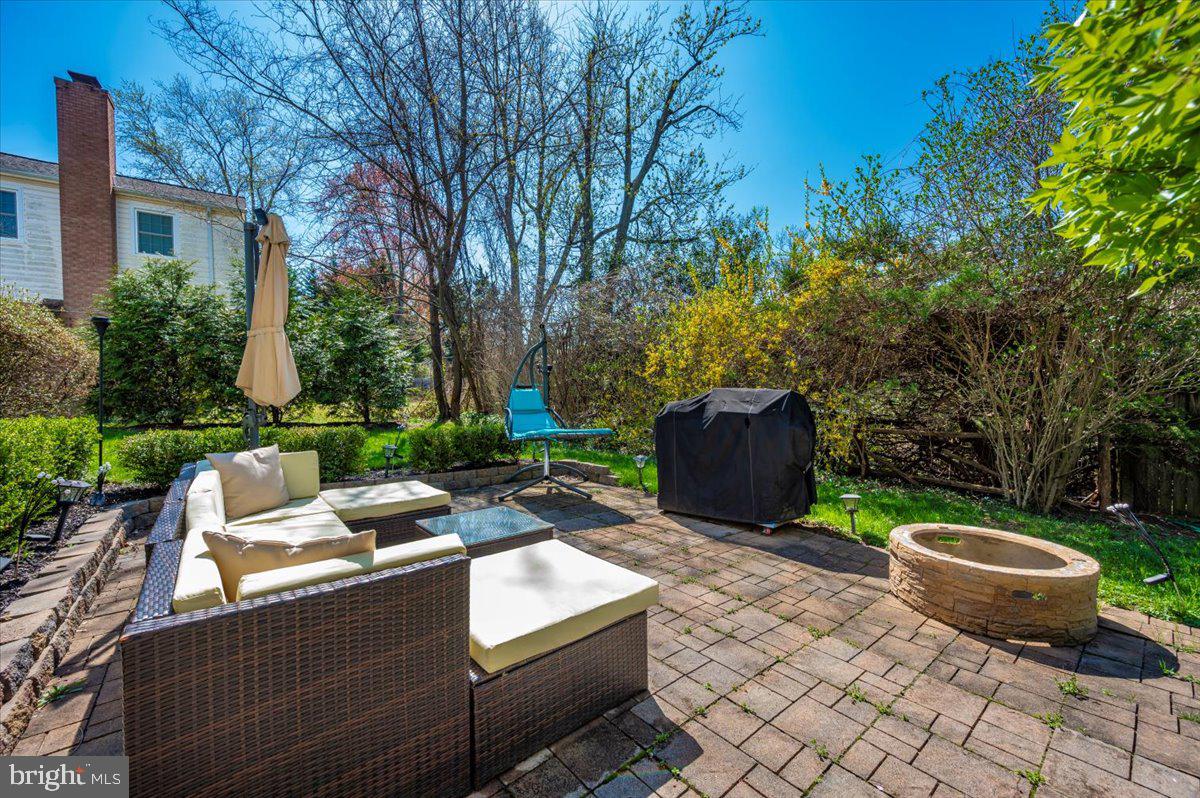 8803 Postoak Road Potomac, MD 20854 - Photo 56 of 66 a view of a backyard with table and chairs potted plants and a large tree