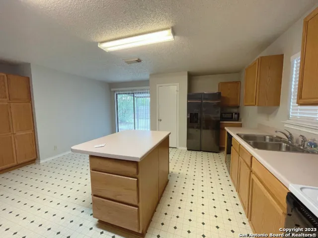 a kitchen with a sink a stove and cabinets