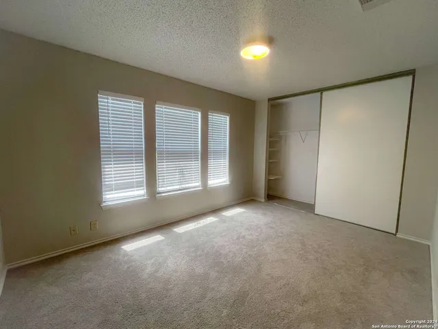 an empty room with windows and closet