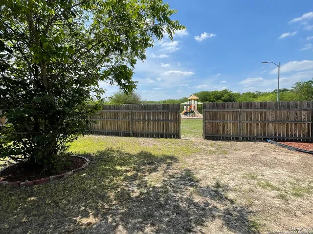 a backyard of a house with a yard and tree