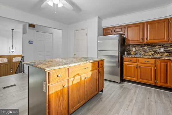 a kitchen with granite countertop cabinets stainless steel appliances and wooden floor