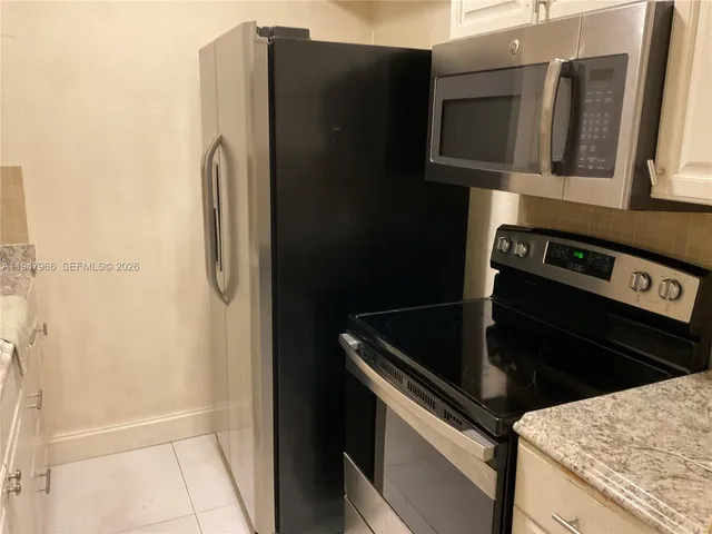 a kitchen with metallic refrigerator and microwave