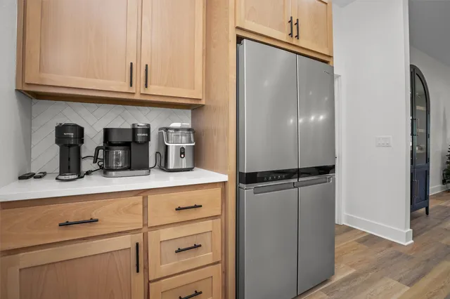 a kitchen with granite countertop a refrigerator and cabinets