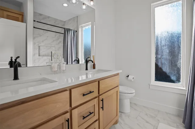 a bathroom with a granite countertop sink toilet and shower