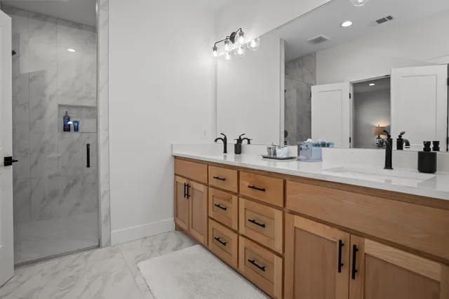 a bathroom with double sink and a mirror