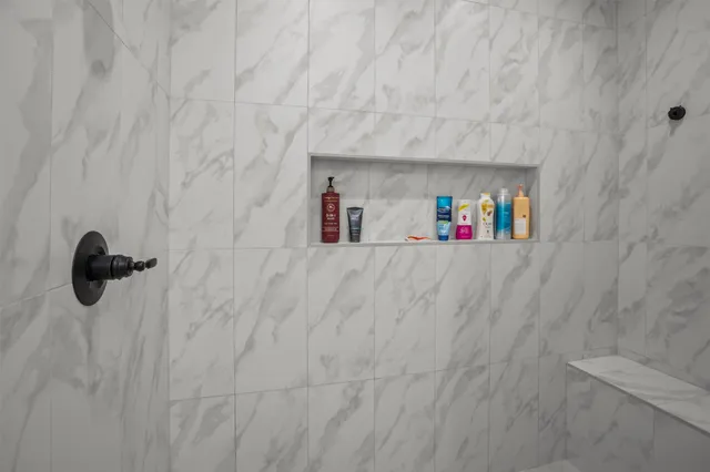 a view of an empty room with wooden floor and a hallway