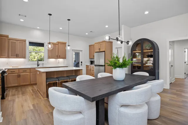a kitchen with a table chairs sink and wooden floor