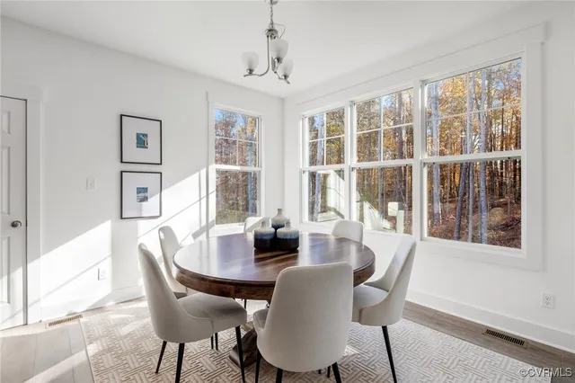 a kitchen with stainless steel appliances a microwave a stove a sink dishwasher a refrigerator and white cabinets with wooden floor