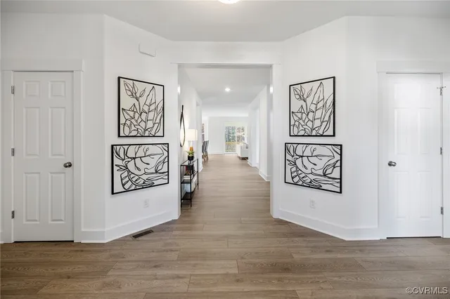 a view of a hallway with wooden floor and wall painting