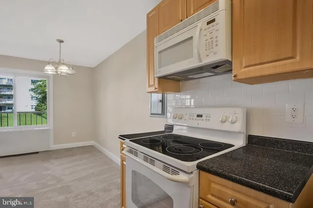 a kitchen with stainless steel appliances granite countertop a stove a microwave and cabinets