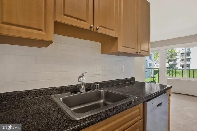 a kitchen with granite countertop a sink and a stove