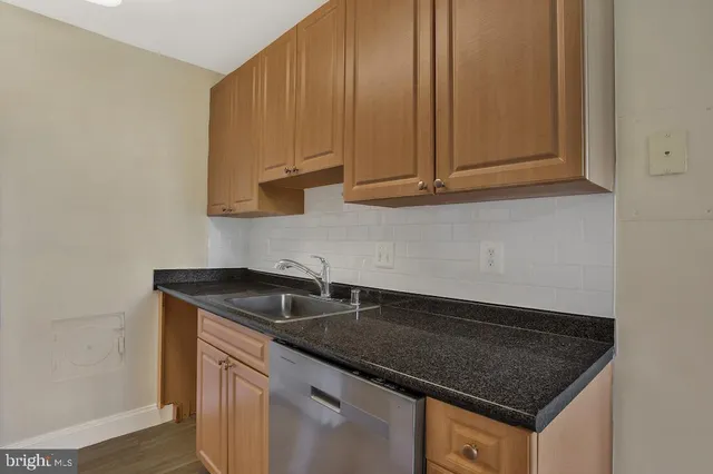 a kitchen with granite countertop a sink and cabinets