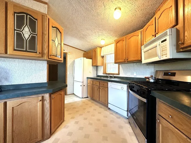 a kitchen with stainless steel appliances granite countertop a stove a sink and a microwave