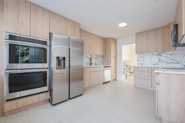 a kitchen with stainless steel appliances granite countertop a sink and a refrigerator