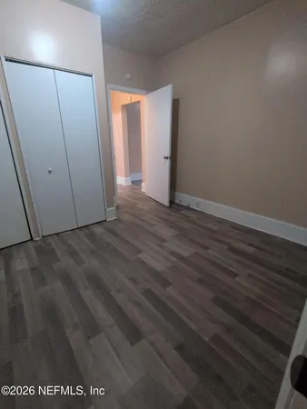 a view of an empty room with wooden floor