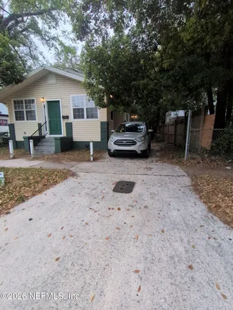 a view of a house with a backyard and a trees
