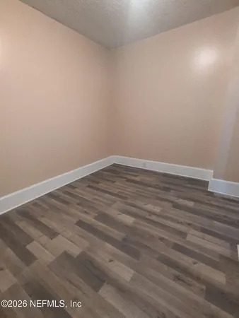 a view of an empty room with wooden floor