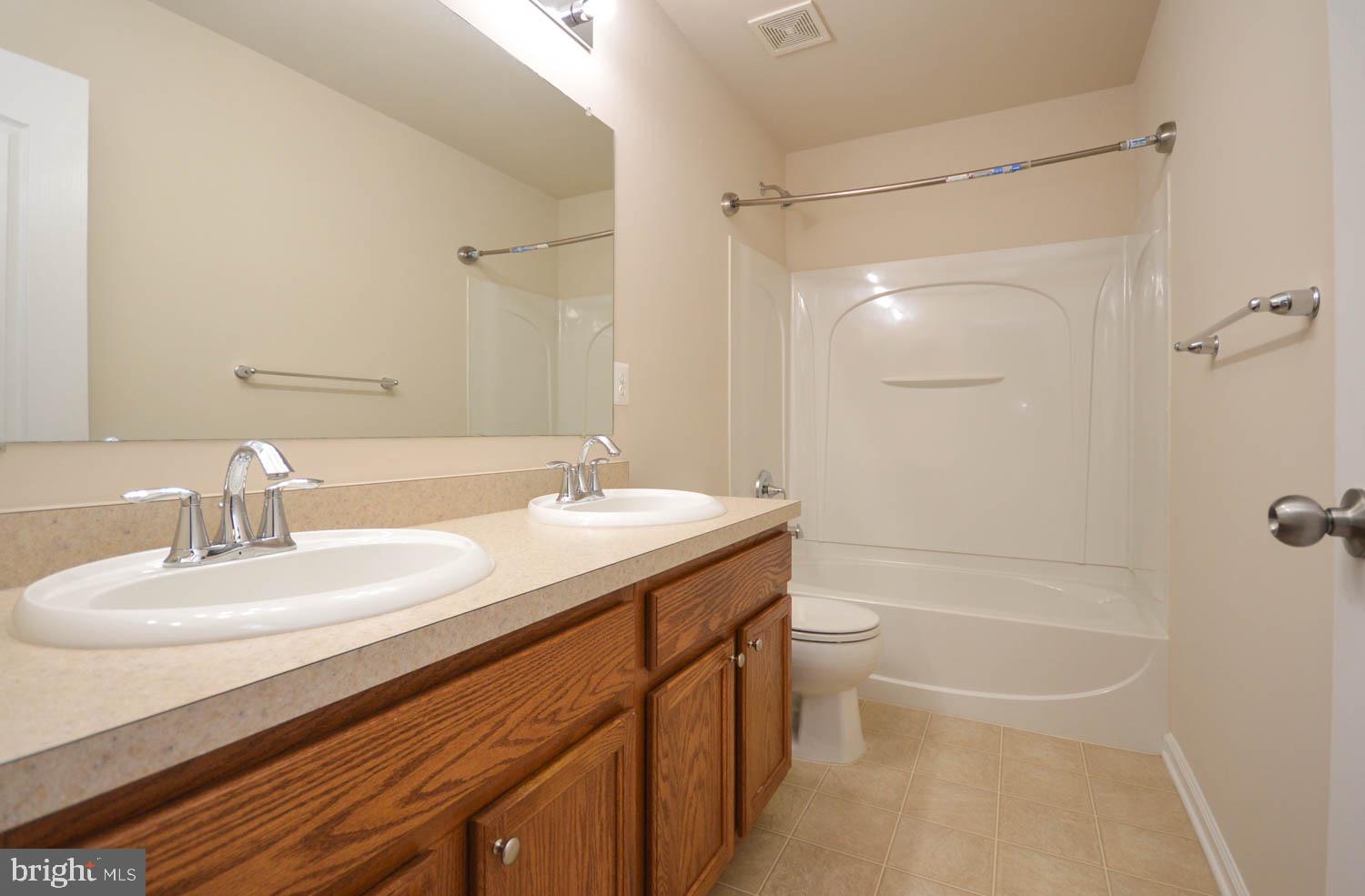 8426 Winding Trail Laurel, MD 20724 - Photo 17 of 41 a bathroom with a granite countertop sink a toilet and shower