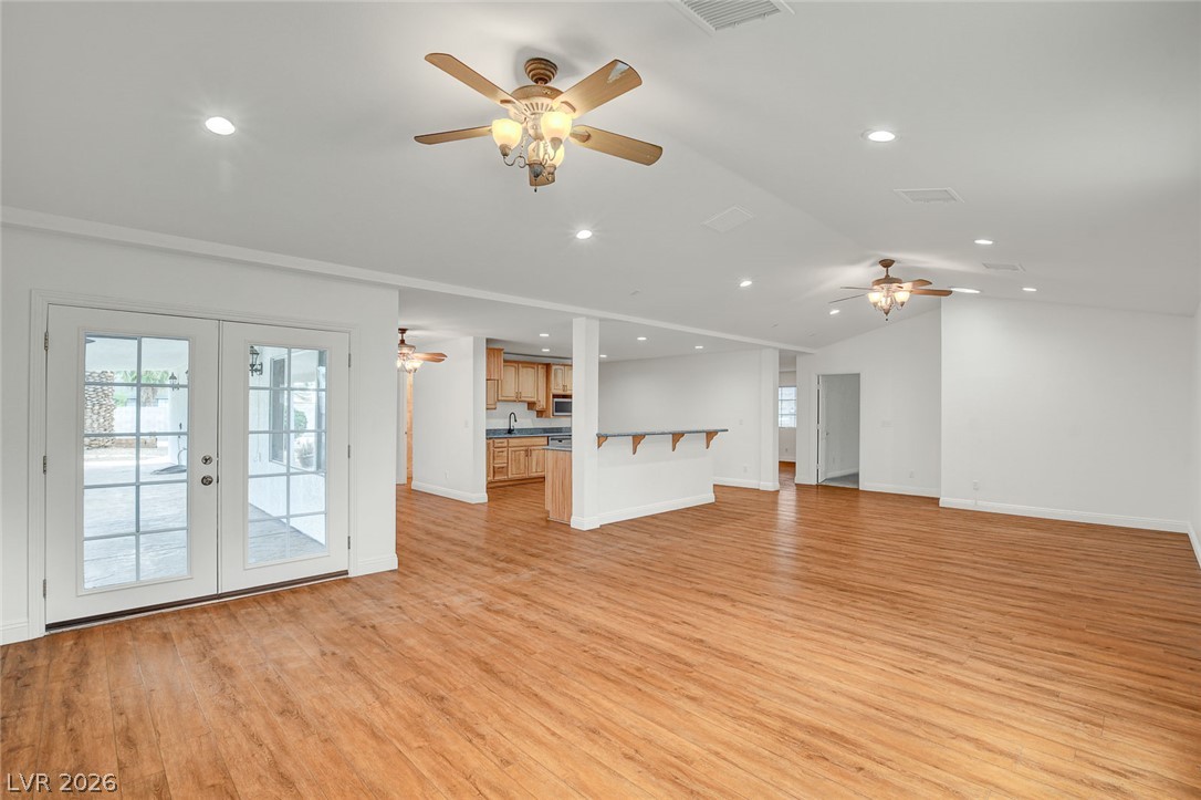 1810 Pinto Road Henderson, NV 89002 - Photo 14 of 53 Natural wood flooring complements this generously proportioned living area with abundant recessed lighting and french doors.
