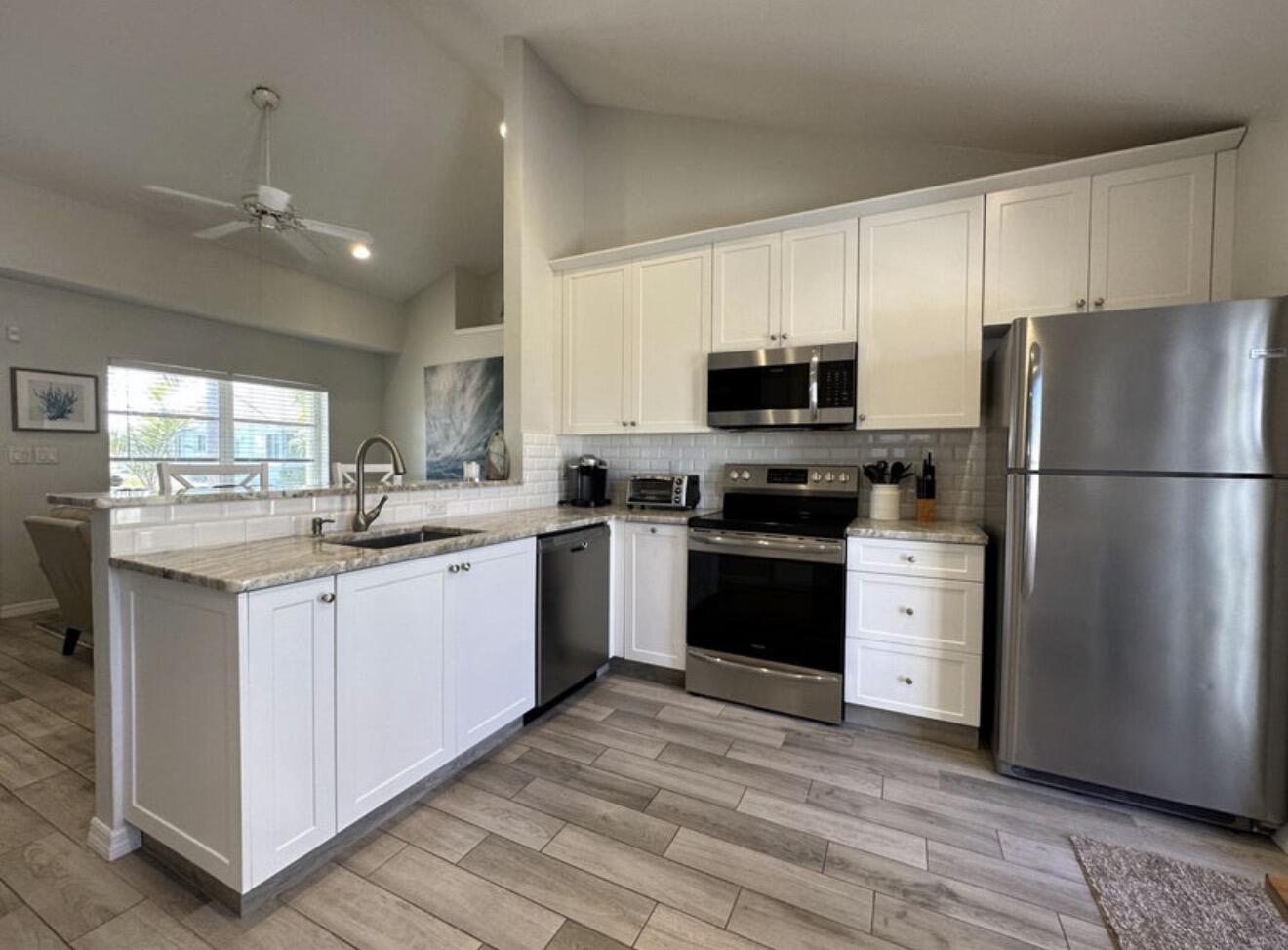 49 Douglas Drive Ocean Ridge, FL 33435 - Photo 20 of 65 a kitchen with granite countertop a refrigerator stove top oven and sink