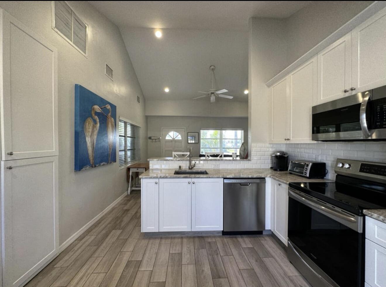 49 Douglas Drive Ocean Ridge, FL 33435 - Photo 22 of 65 a kitchen with stainless steel appliances granite countertop wooden cabinets a stove top oven a sink and dishwasher