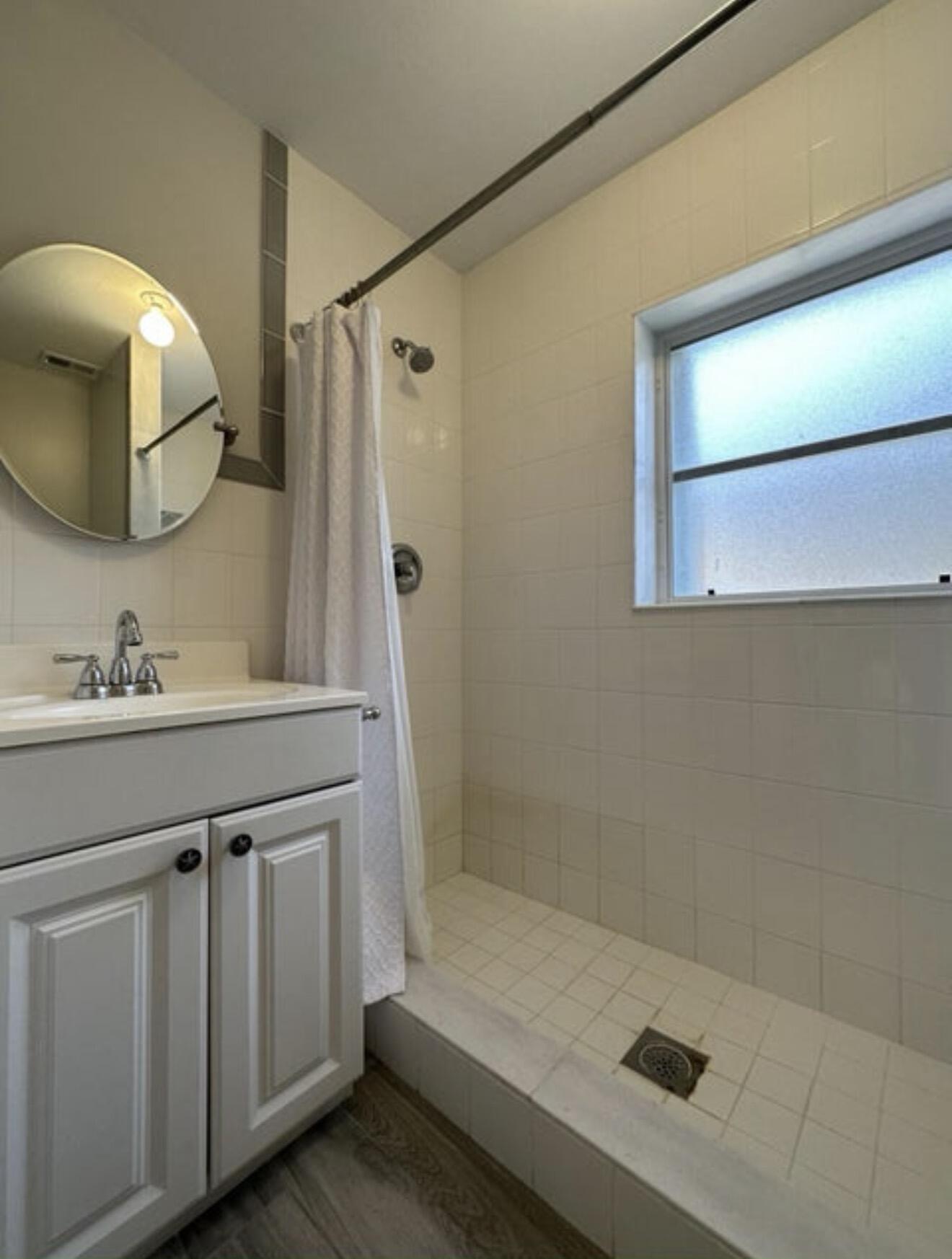 49 Douglas Drive Ocean Ridge, FL 33435 - Photo 24 of 65 a bathroom with a sink a mirror and a shower
