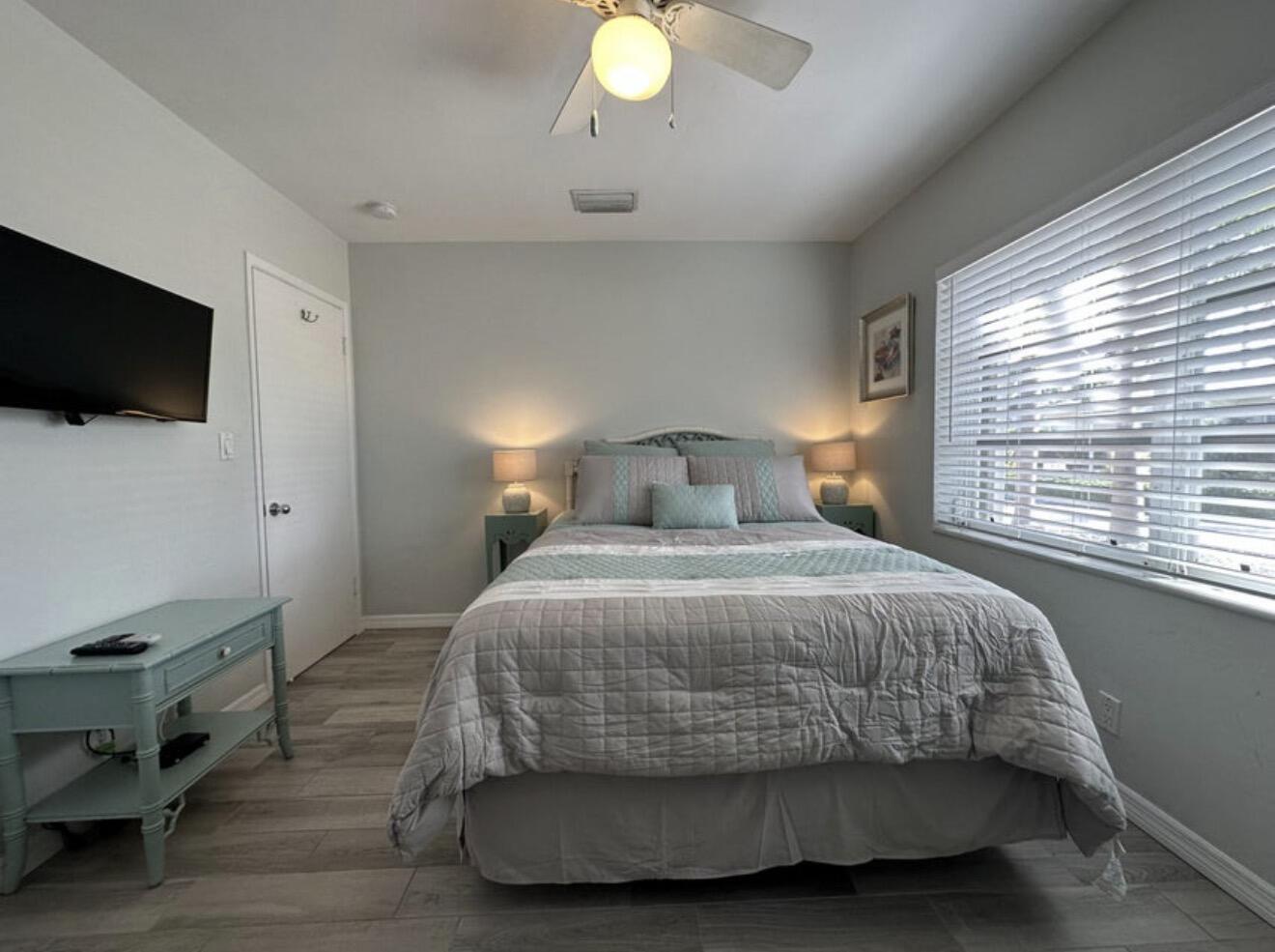 49 Douglas Drive Ocean Ridge, FL 33435 - Photo 31 of 65 a bedroom with a bed and a flat tv screen on the dresser