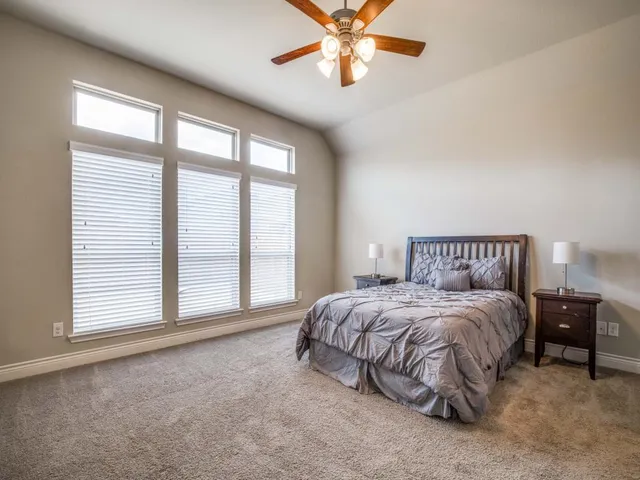 a spacious bedroom with a bed and a large window