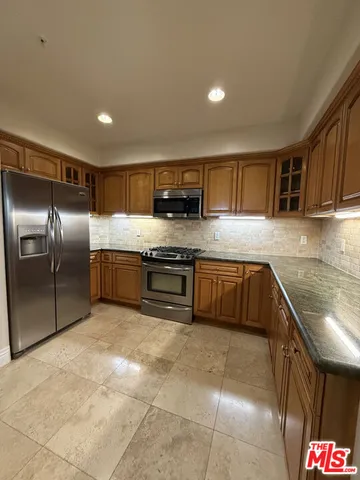 a kitchen with stainless steel appliances granite countertop a stove a sink and a refrigerator