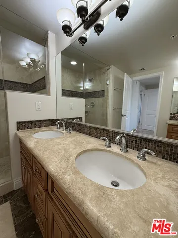 a bathroom with a granite countertop sink a toilet and a mirror