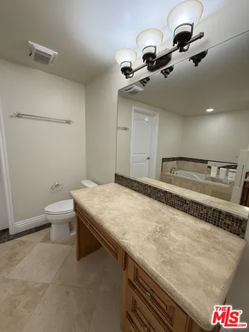 a spacious bathroom with a granite countertop sink and a mirror