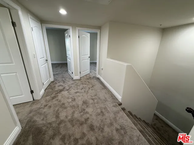 an empty room with cabinet and mirrors