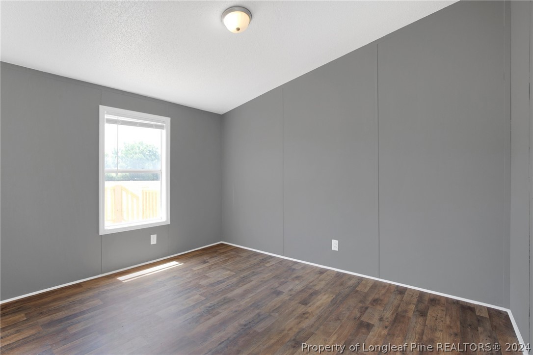 152 Three Bridges Road Rowland, NC 28383 - Photo 18 of 27 an empty room with wooden floor and windows