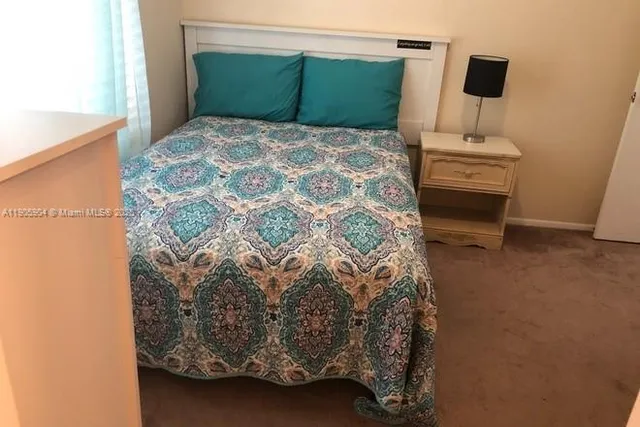 a bedroom with a bed and a potted plant